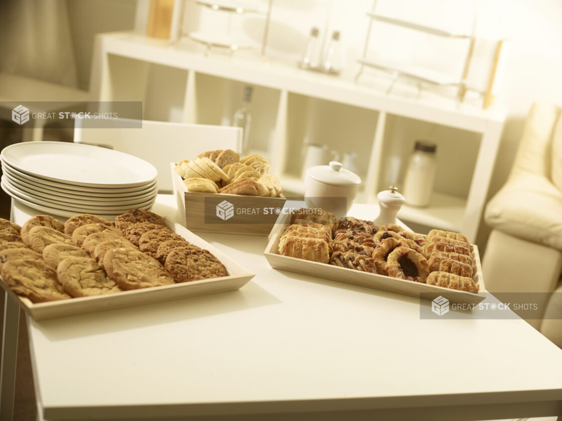 Mini danish tray, cookie tray and small bread box with white side plates on a white table in a party setting