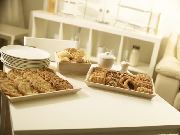 Mini danish tray, cookie tray and small bread box with white side plates on a white table in a party setting