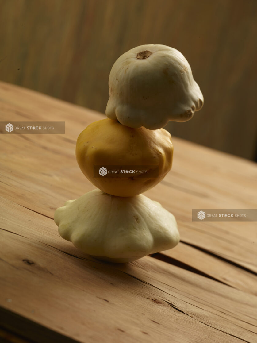 3 mini gourds stacked on top of each other on a wooden background