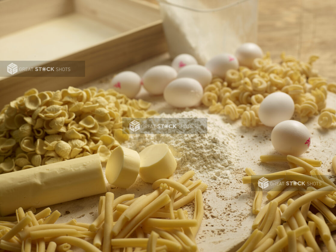 Making pasta, fresh made pasta with flour, eggs, butter on a board