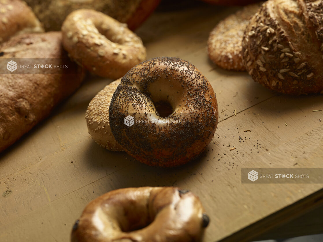 Assorted rustic bagels and breads in a close up view on a wooden table