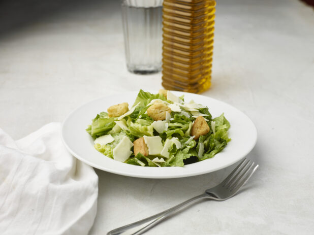 Caesar salad with white napkin on a white table cloth