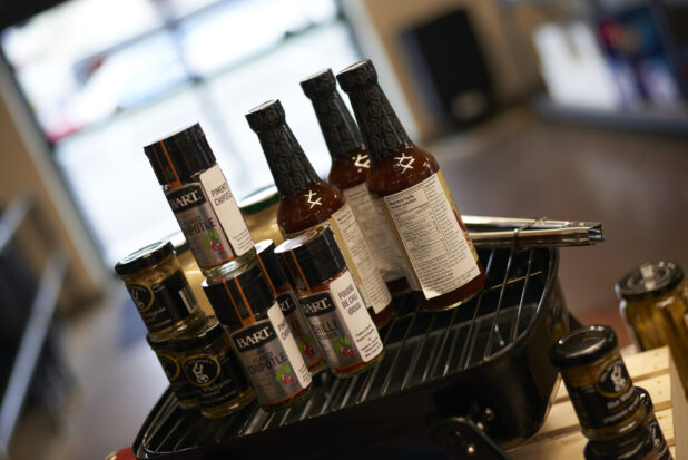 Sauces, Condiments and Seasonings for Grilling Season Displayed on a Grilling Pan in a Gourmet Grocery Store