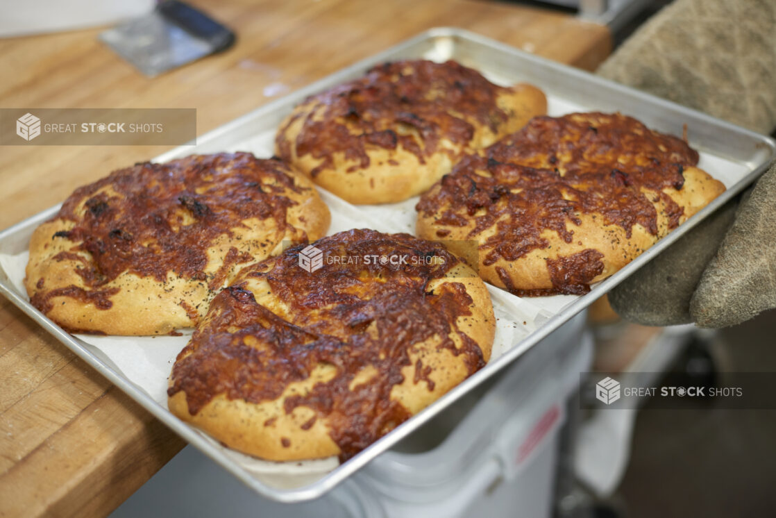 Close Up of a Sheet Pan of Fresh Baked Mini Cheese Buns in the Kitchen of a Gourmet Grocery Store