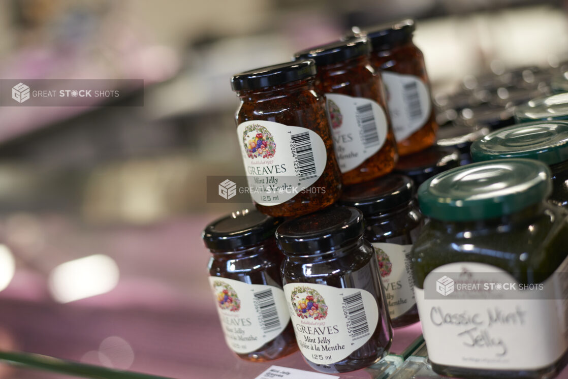 Jars of mint jelly stacked, retail display, close-up