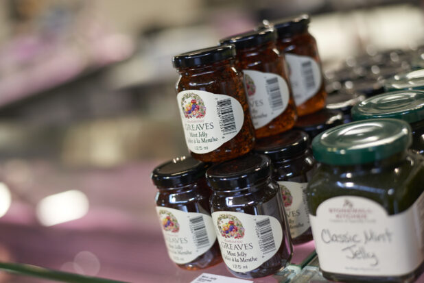 Jars of mint jelly stacked, retail display, close-up