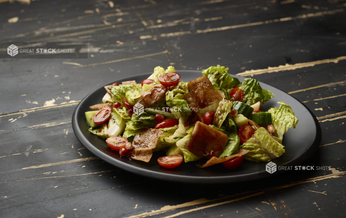 Garden Salad with Gyro Meat and Balsamic Vinaigrette Drizzle on a Black Ceramic Dish on a Black Painted Wooden Table