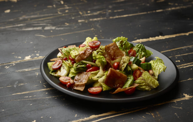 Garden Salad with Gyro Meat and Balsamic Vinaigrette Drizzle on a Black Ceramic Dish on a Black Painted Wooden Table