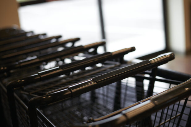 Line of nested steel shopping carts, close-up, bokeh effect