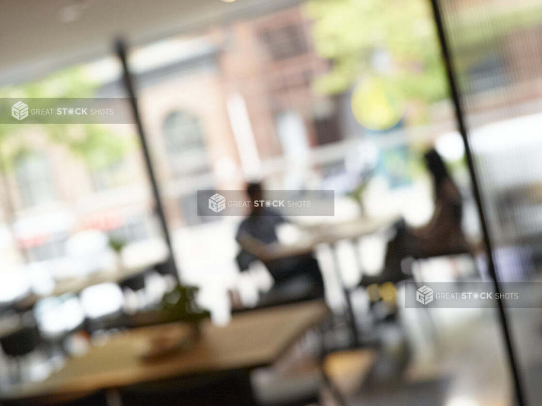 Extreme Blurred Shot of a Restaurant Interior with Customers, Overlooking a Busy City Street