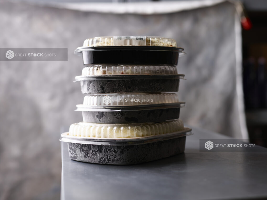 Stack of frosty plastic bakery containers, neutral palette