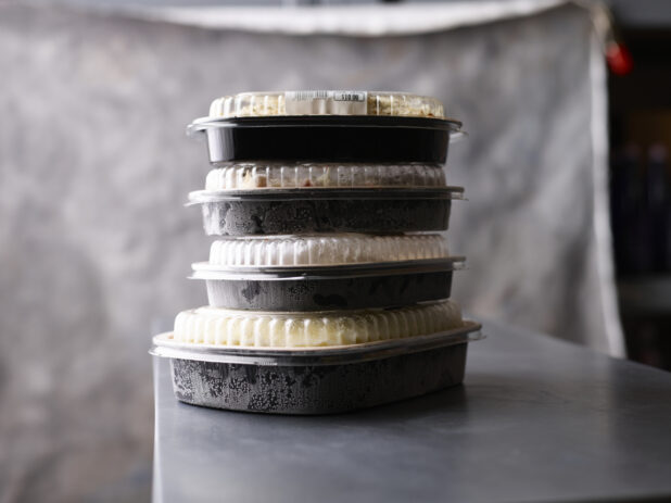 Stack of frosty plastic bakery containers, neutral palette