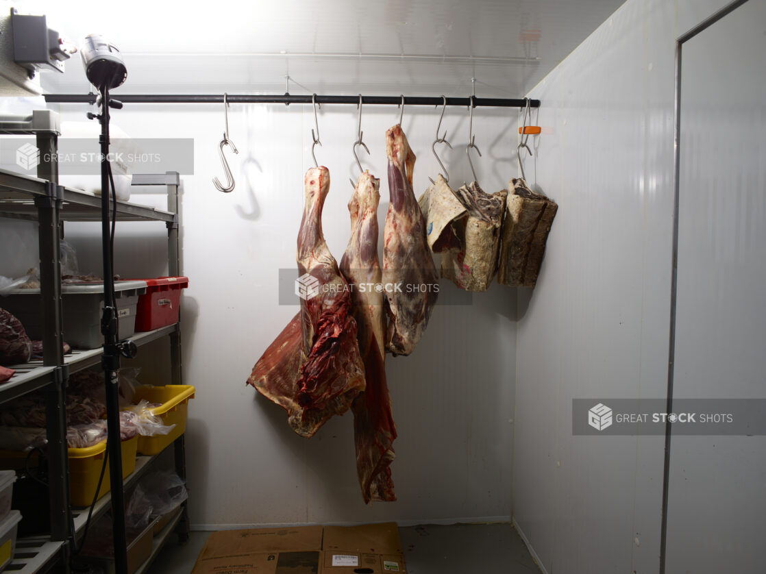 Assorted beef parts hanging on hooks