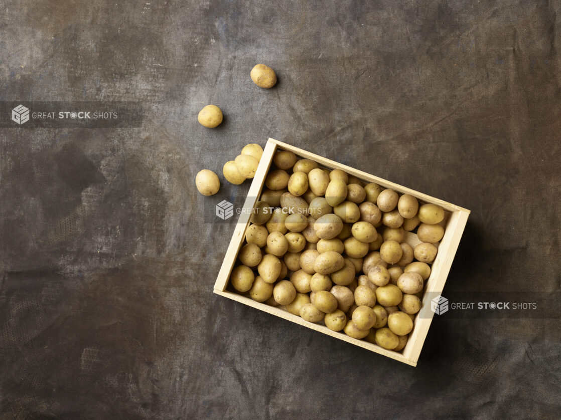 Wooden crate of white new potatoes