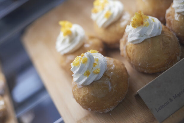 Choux pastries topped with whipped cream and candied citrus