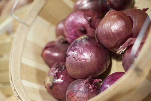 Bushel basket of red onions, close-up