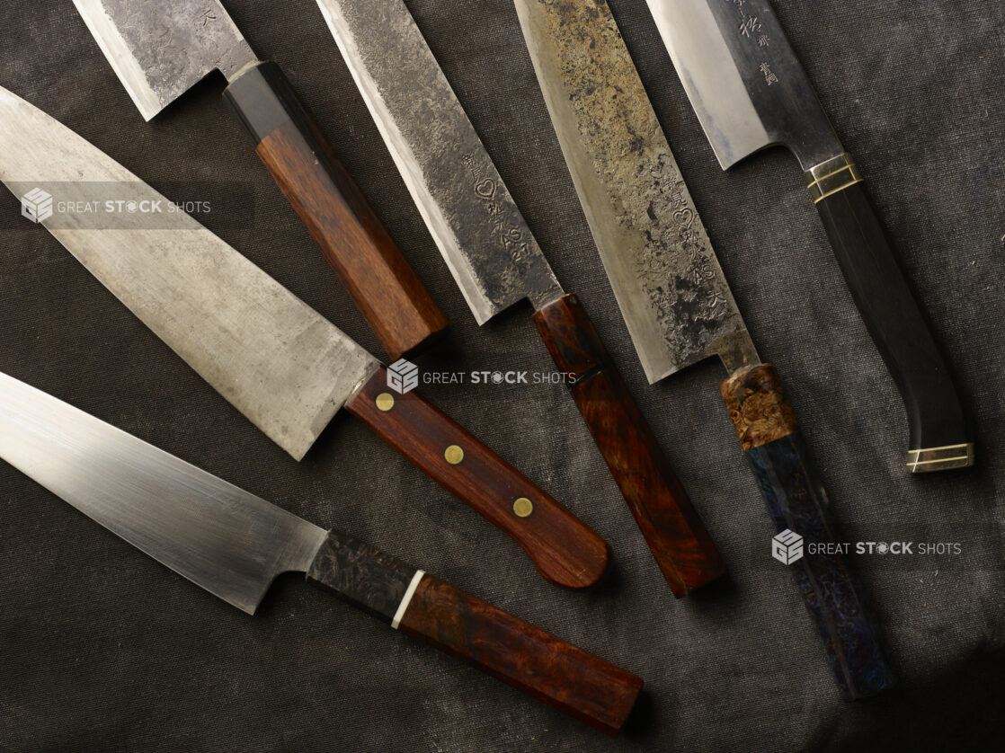 A collection of Japanese kitchen knives on a dark cloth background