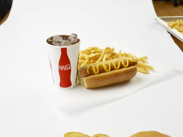 Hot Dog Combo with Yellow Mustard, French Fries and a Fountain Soda in a Paper Cup with Ice Cubes, on a White Background for Isolation