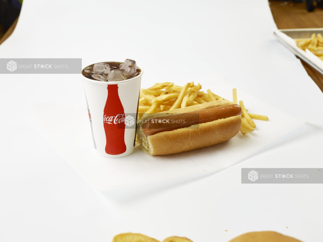 Plain Hot Dog Combo with French Fries and a Fountain Soda in a Paper Cup with Ice Cubes, on a White Background for Isolation