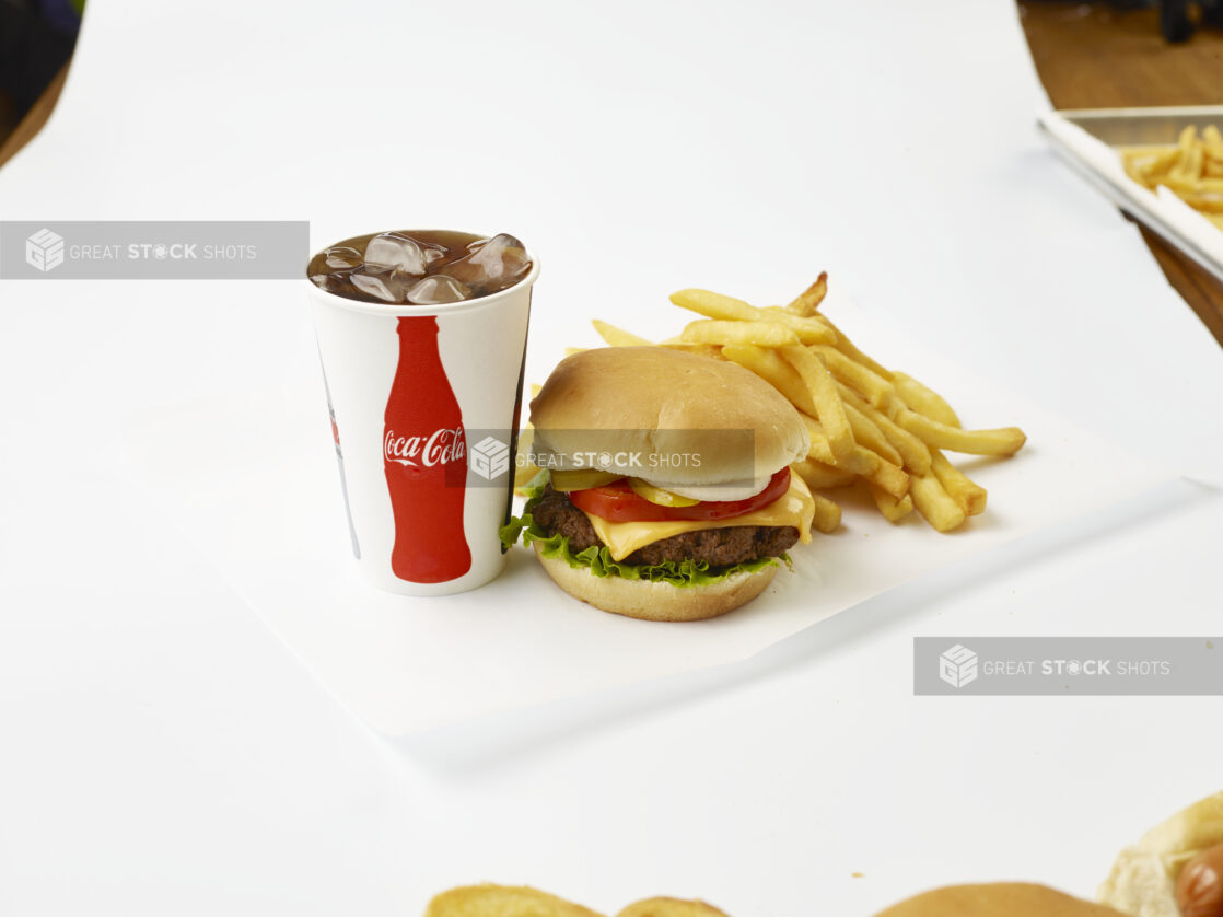 Cheeseburger Combo with Fresh Toppings, French Fries and a Fountain Soda in a Paper Cup with Ice Cubes, on a White Background for Isolation - Variation