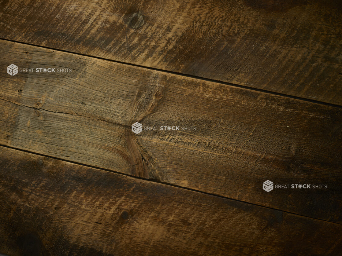 Full background of aged dark wood planks with rustic saw marks, tilted