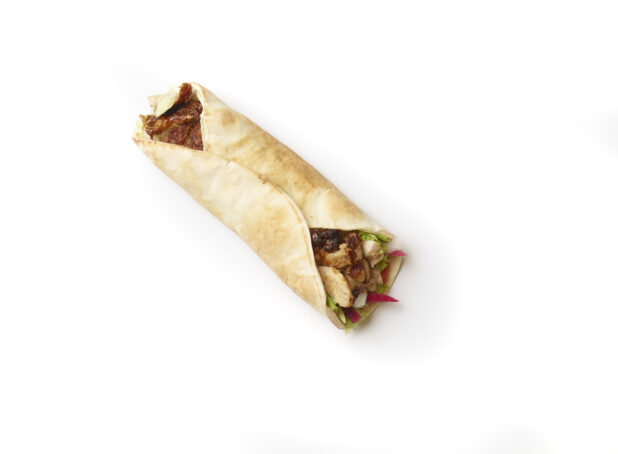 Overhead View of a Chicken Shawarma Pita Wrap with Fresh Vegetable Toppings, Shot on White for Isolation