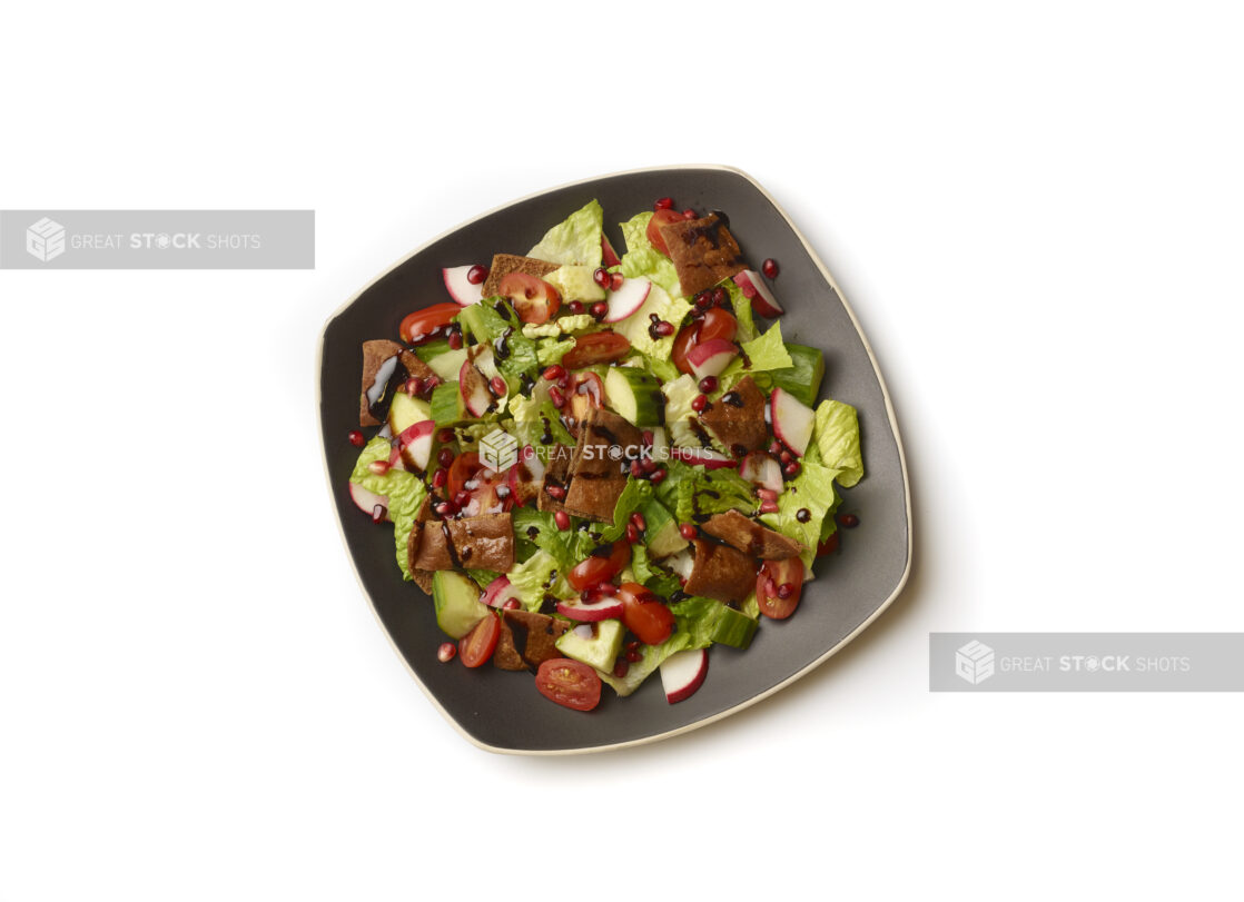 Overhead View of a Garden Salad with Gyro Meat and Balsamic Vinaigrette Drizzle on a Square Black Ceramic Dish, on a White Background for Isolation