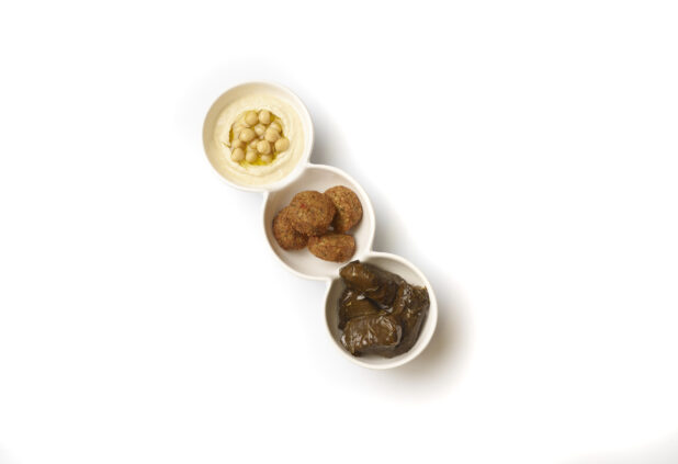 Overhead View of a Trio Plate of Side Dishes: Falafel Balls, Stuffed Grape Leaves and Hummus, on a White Background for Isolation