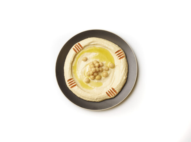 Overhead View of a Plate of Hummus Dip with Extra Virgin Olive Oil and Paprika Powder, Shot on a White Background for Isolation