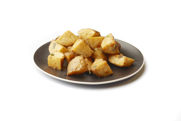 Garlic Potatoes on a Round Black Ceramic Dish, on a White Background for Isolation