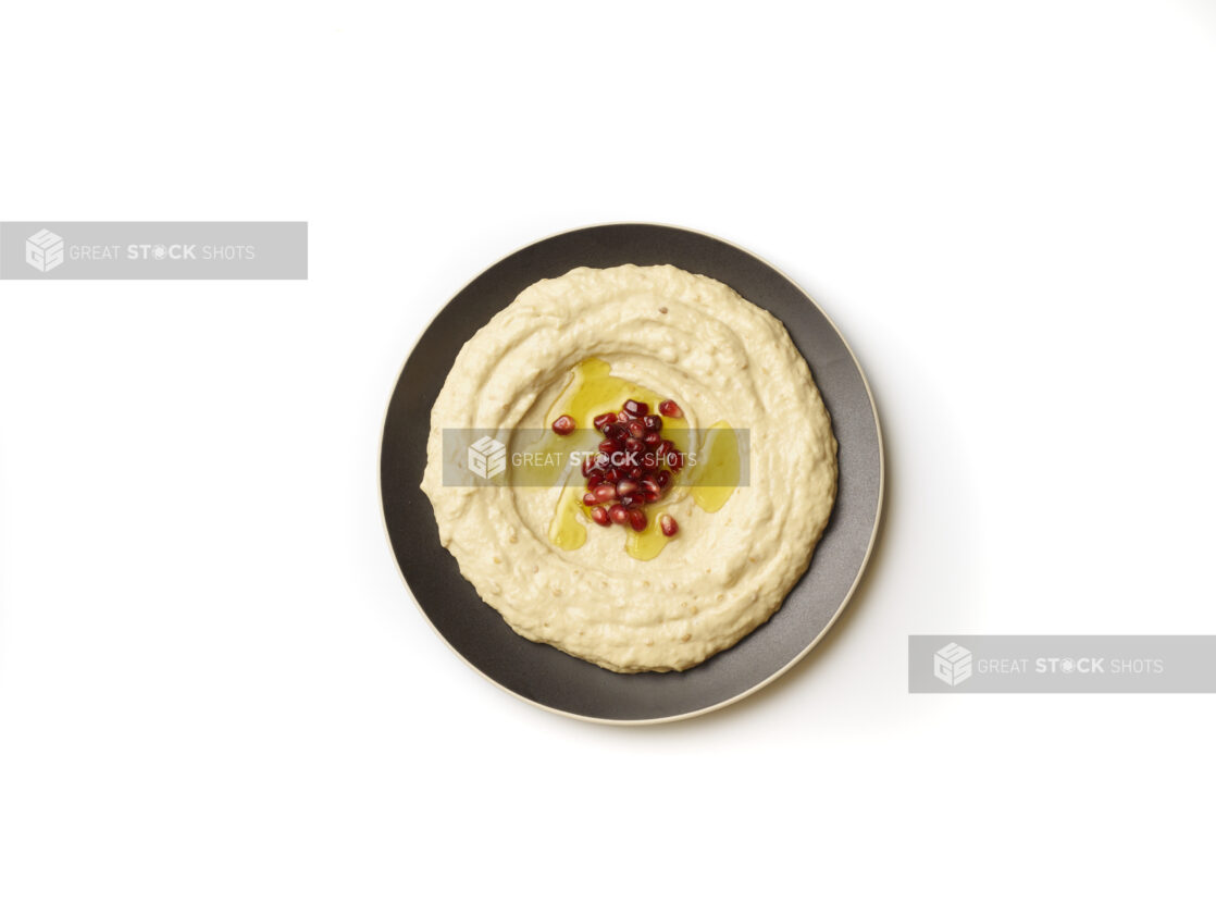 Overhead View of a Plate of Baba Ganoush Creamy Eggplant Dip with EVOO and Pomegranate Seeds, Shot on White for Isolation