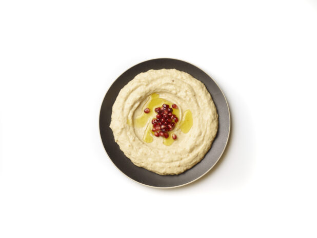 Overhead View of a Plate of Baba Ganoush Creamy Eggplant Dip with EVOO and Pomegranate Seeds, Shot on White for Isolation