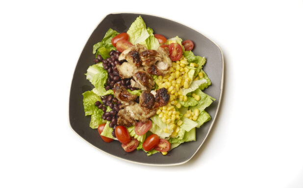 Overhead View of a Chicken Shawarma Salad with Corn and Black Beans on a Square Black Ceramic Dish, on a White Background for Isolation
