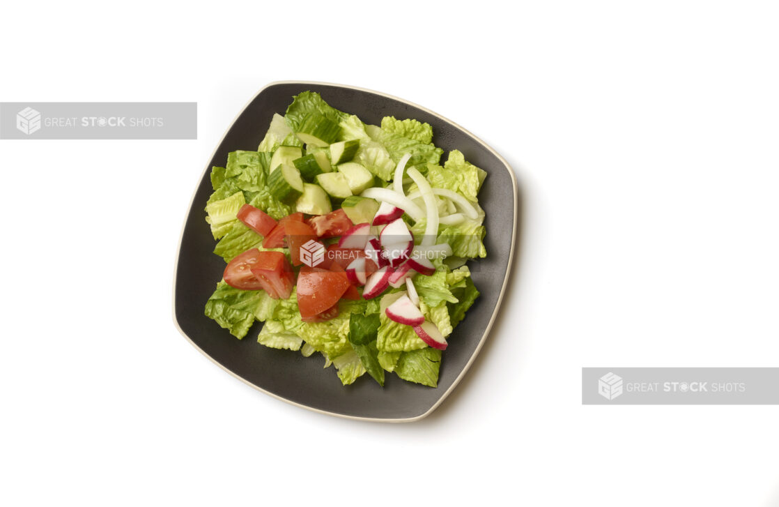 Overhead View of a Plain Garden Salad with Chopped Tomatoes, Cucumber, Radish and White Onions on a Square Black Ceramic Dish, on a White Background for Isolation