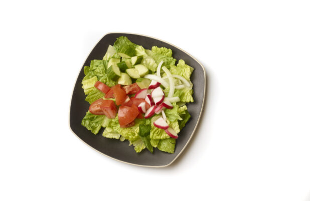 Overhead View of a Plain Garden Salad with Chopped Tomatoes, Cucumber, Radish and White Onions on a Square Black Ceramic Dish, on a White Background for Isolation