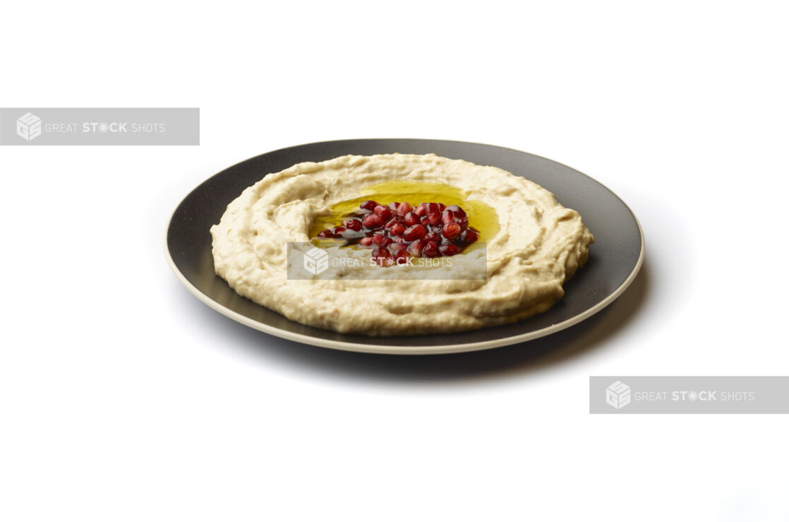 Plate of Baba Ganoush Creamy Eggplant Dip with EVOO and Pomegranate Seeds, Shot on White for Isolation