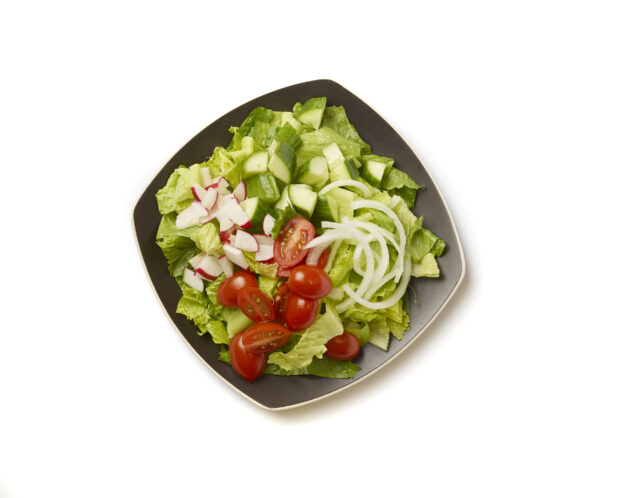 Overhead View of a Plain Garden Salad with Cherry Tomatoes, Cucumber, Radishes and White Onions on a Square Black Ceramic Dish, on a White Background for Isolation