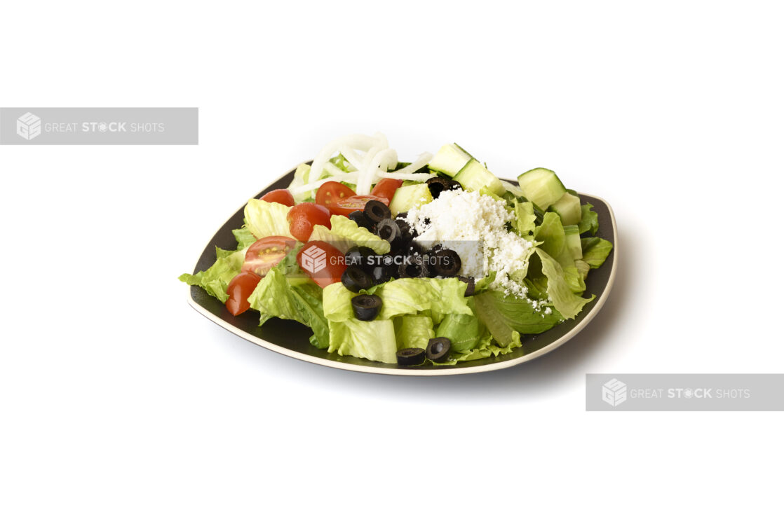 Plain Greek Salad with Cherry Tomatoes, Cucumber, Black Olives, Feta and White Onions on a Square Black Ceramic Dish, on a White Background for Isolation