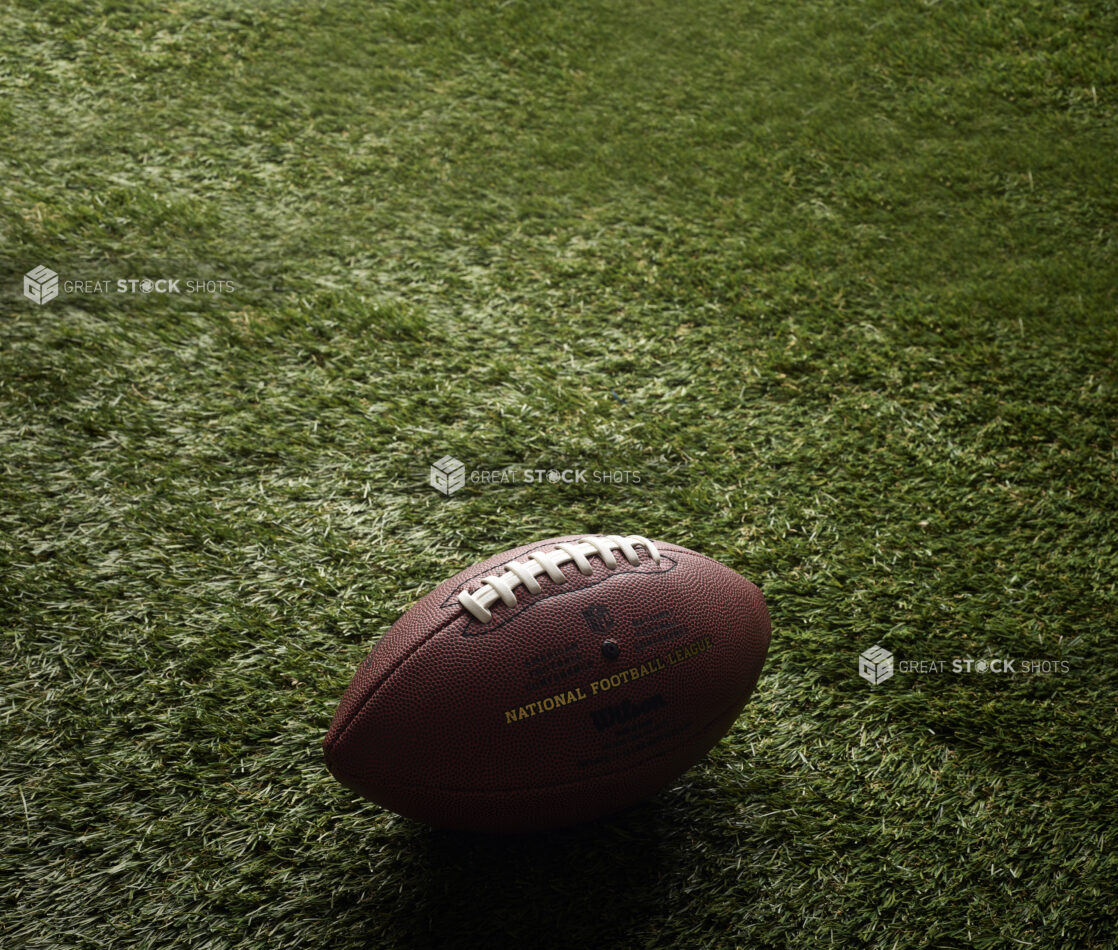 Close Up of an American Football on Astroturf in an Outdoor Setting