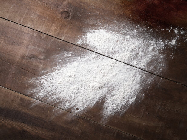 Overhead View of Flour Thrown Across a Dark Wooden Panelled Surface