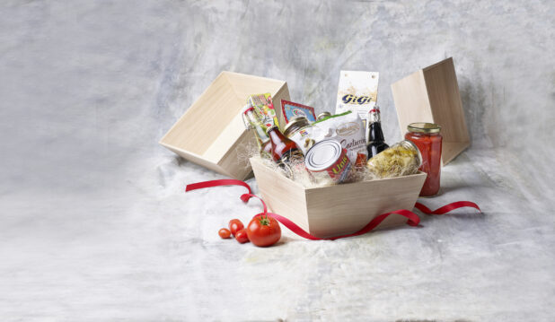 Deep Square Wood Tray Gift Basket Filled with Italian Pantry Products, Jars and Canned Goods with a Red Ribbon Against a Canvas Background