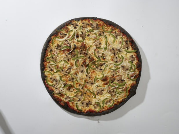 Overhead View of a Whole Charcoal-Infused Veggie Pizza with White Onions, Green Peppers and White Mushrooms Toppings, on a White Background for Isolation