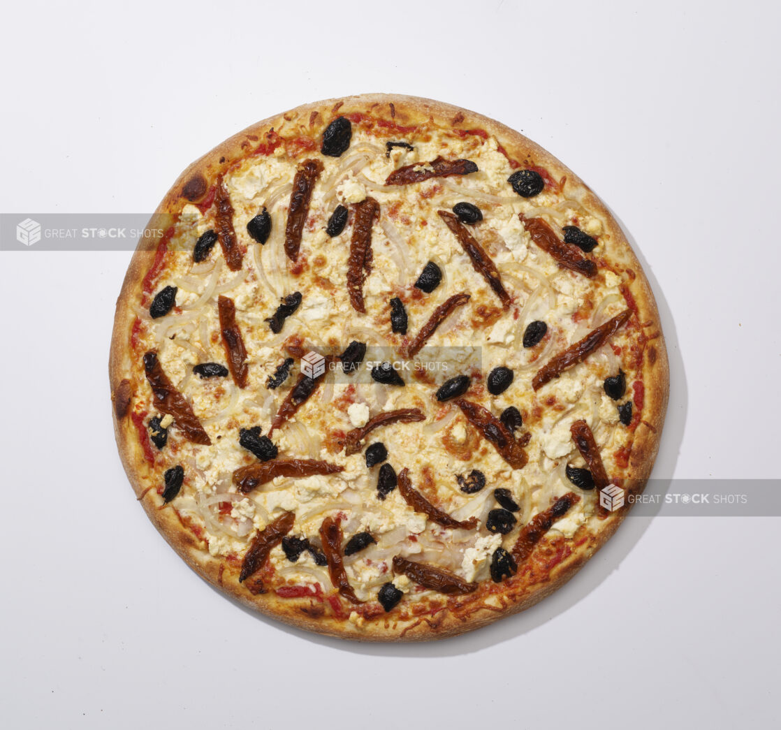 Overhead View of a Whole Specialty Pizza with Sun-dried Tomatoes, Black Olives, White Onions and Feta Cheese, on a White Background for Isolation