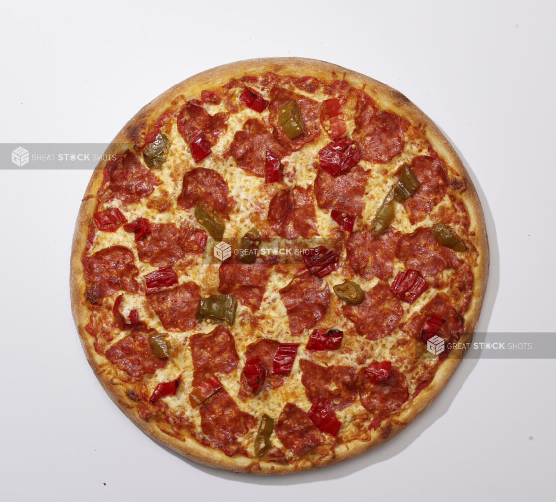 Overhead View of a Whole Specialty Pizza with Spicy Soppressata Salami and Hot Peppers, on a White Background for Isolation