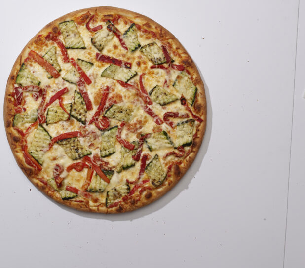 Overhead View of a Whole Specialty Pizza with Roasted Zucchini, Roasted Red Peppers, Parmesan Cheese Toppings, on a White Background for Isolation