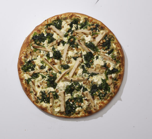 Overhead View of a Whole Chicken Florentine Pizza with Sautéed Spinach, Feta Cheese, Roasted Garlic and Grilled Chicken, on a White Background for Isolation