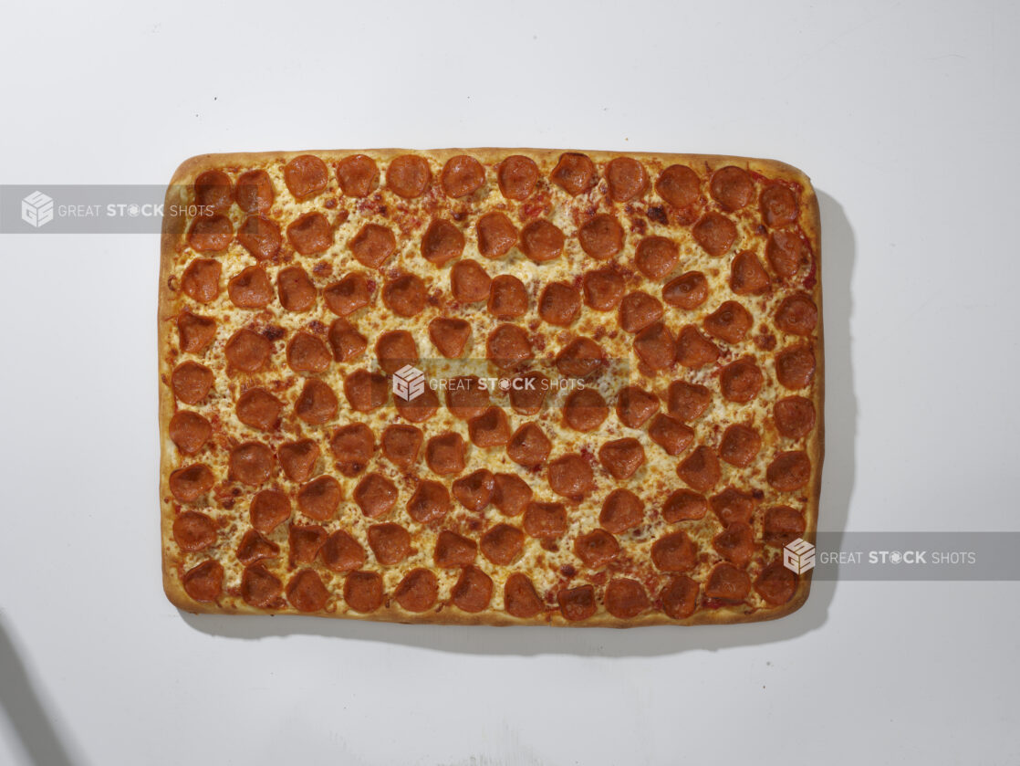 Overhead View of a Whole Party Pizza with Pepperoni and Cheese Toppings, on a White Background for Isolation