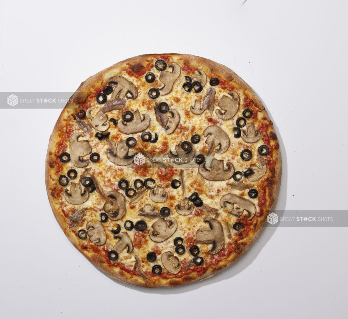 Overhead View of a Whole Specialty Pizza with White Mushrooms, Black Olives and Anchovies, on a White Background for Isolation