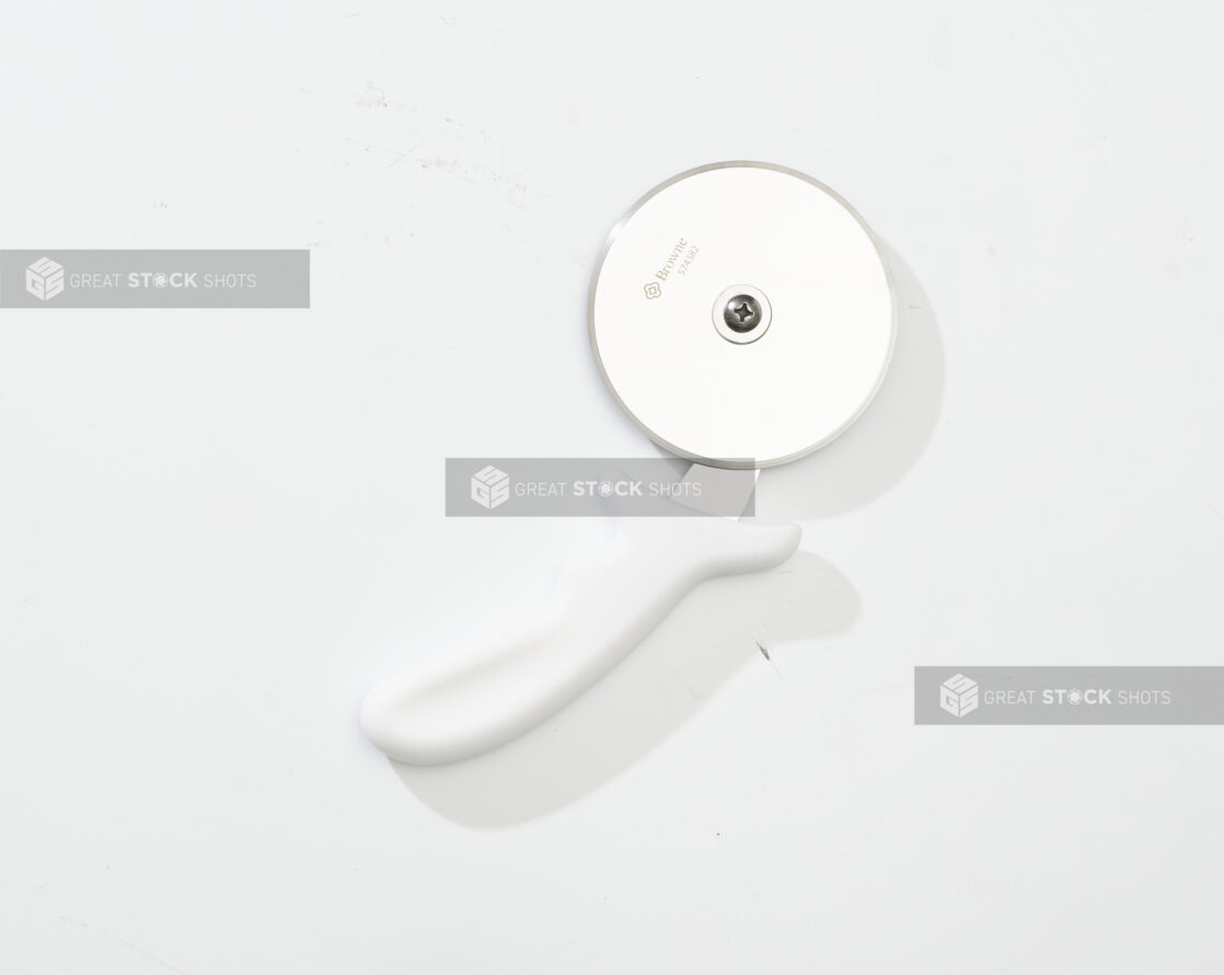 Overhead View of a Pizza Cutter with a White Handle, on a White Background for Isolation