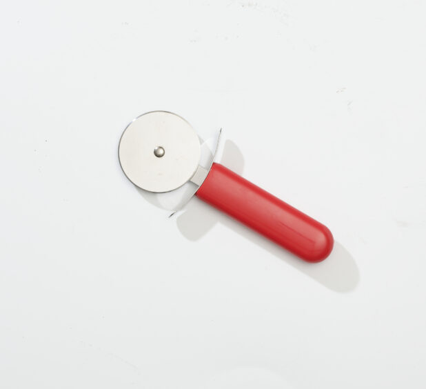 Overhead View of a Pizza Cutter with a Red Handle, on a White Background for Isolation